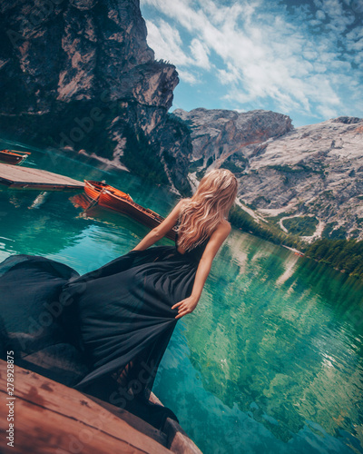 Girl in a black dress on the background of the turquoise lake in mountain. Dolomites Alps  lago di Braies  Italy