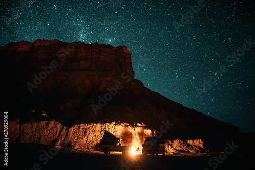 Lagerfeuer umstellt von einem Geländewagen und Campervan in der Nacht bei erg chebbi bei merzouga in Marokko unter einem Sternenhimmel  photo