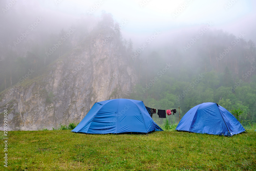 Tents stand in the outdoors mountains, morning mist and fog