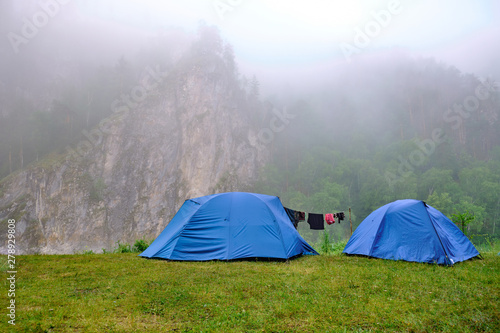 Tents stand in the outdoors mountains  morning mist and fog