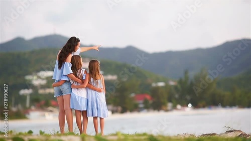 Beautiful mother and daughters on Caribbean beach in sunset.