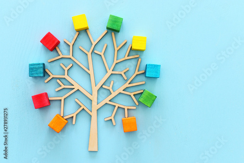 Business image of wooden tree with colorful cubes over blue table, human resources and management concept #278931275