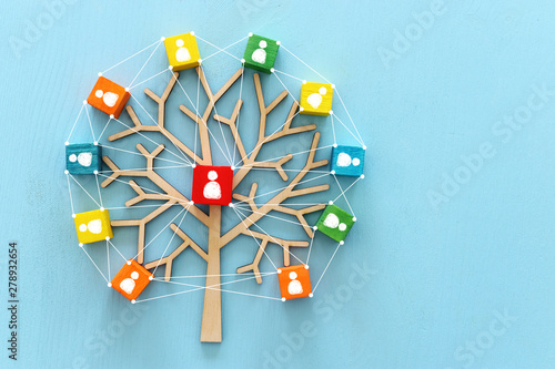 Business image of wooden tree with people icons over blue table, human resources and management concept photo