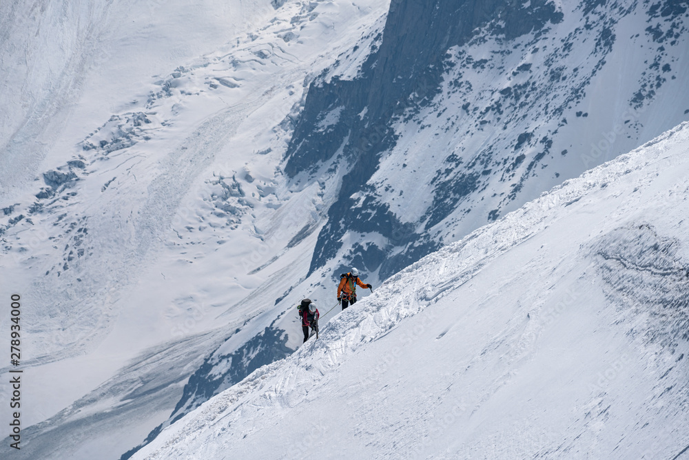 Moutaineers climbing of snowy mountain