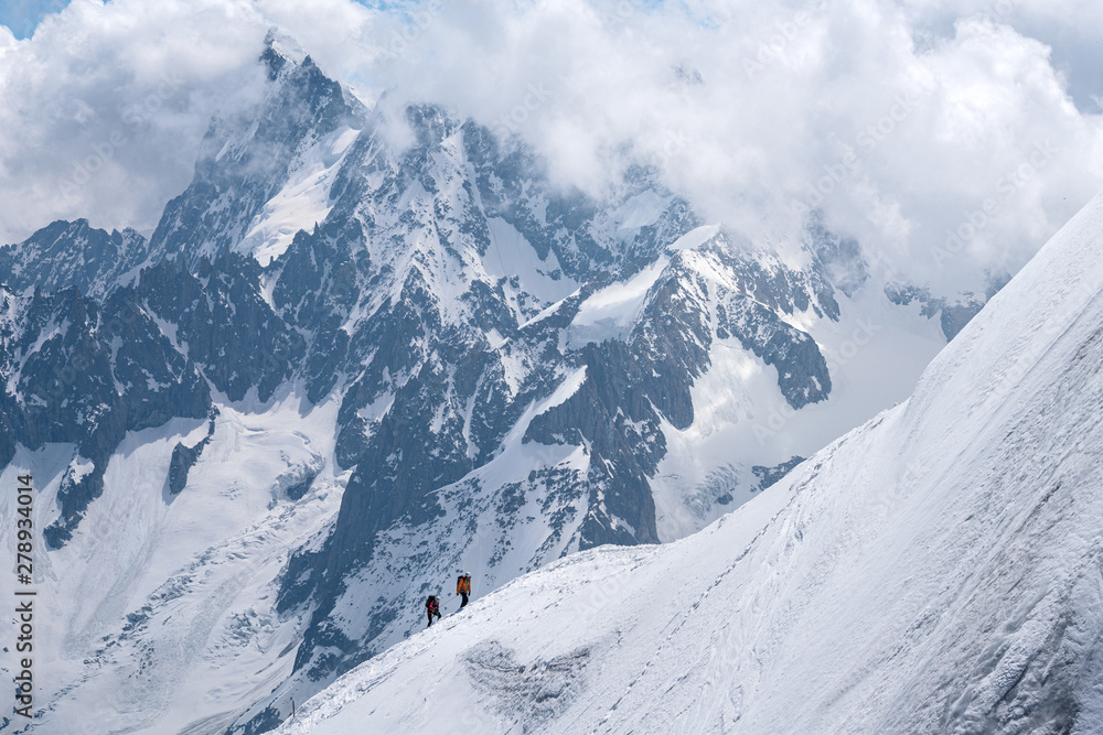 Mountaineers ascending on steep and snowy slope in Chamonix, France