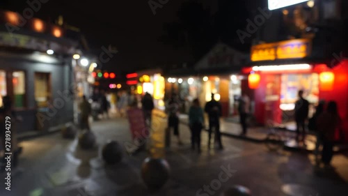 Lively night street with people walking in Beijing, defocused. China. photo