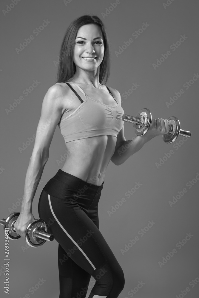 Athletic woman with dumbbells doing sport exercise Athletic woman with dumbbells doing sport exercise