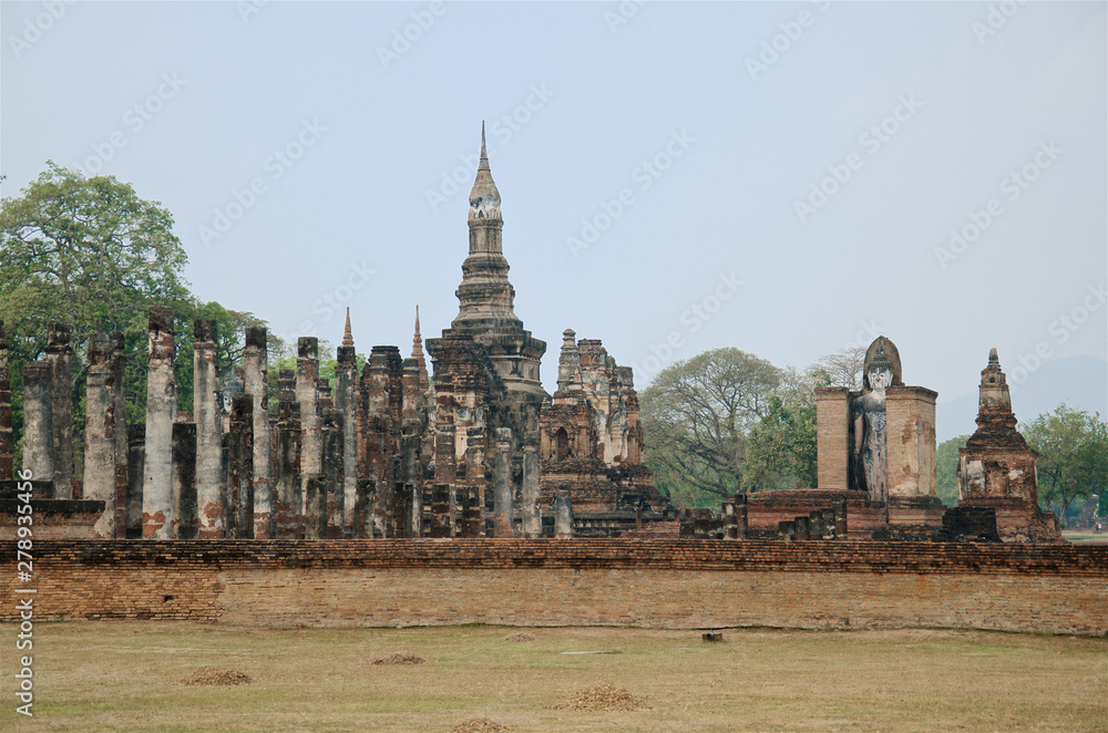 Obraz premium Ruins of unique temples in famous Sukhothai Historical Park, a UNESCO World Heritage Site, Foggy spring day in the ancient 13th and 14th centuries capital of Sukhothai. Thailand