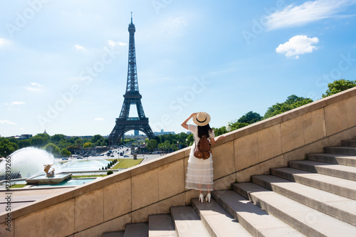 Woman tourist is enjoy siteseeing Eiffle Tower landmark of France, Paris during summer time. photo