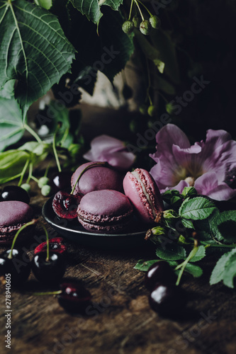 Macarons decorated with flowers on a dark rustic background
