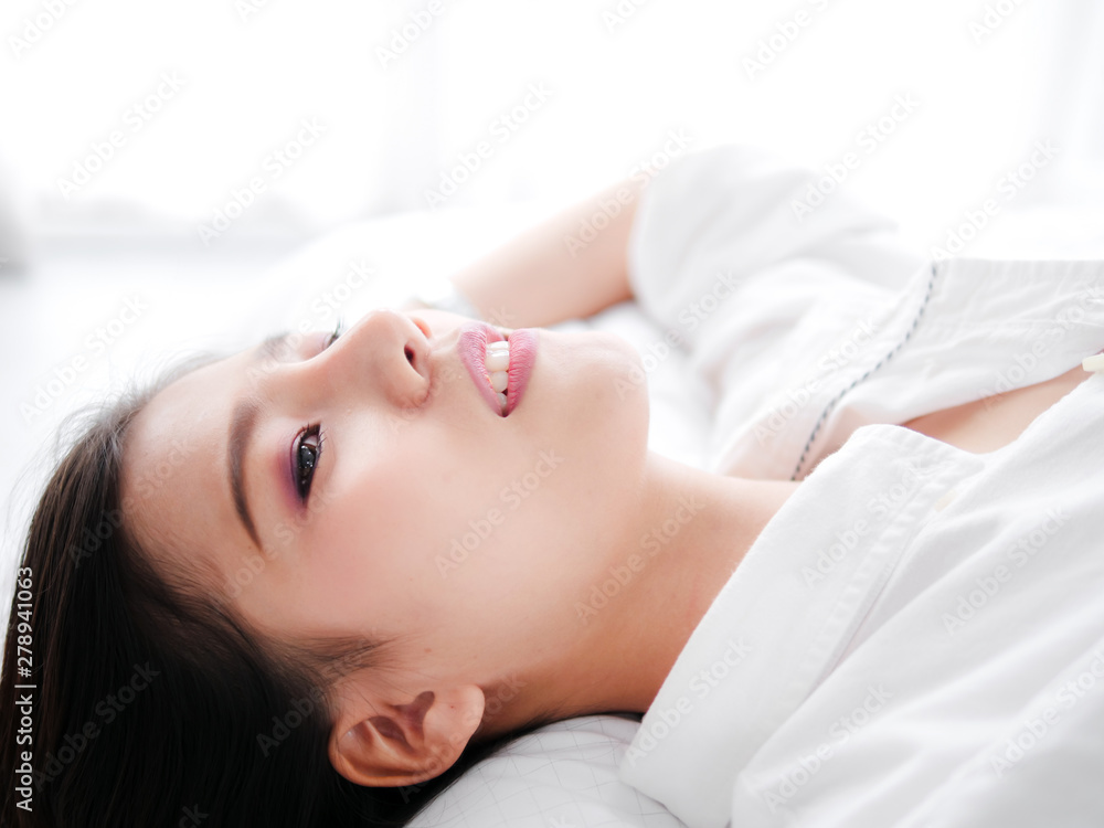 Happy Asian woman lying on bed, closed up. Happy Asian woman lying on bed, closed up.