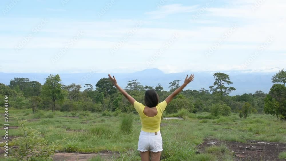 The image behind the women raise their arms looked at the mountains and trees at Phu Hin Rong Kla National Park , Phetchabun in Thailand. The image behind the women raise their arms looked at the mountains and trees at Phu Hin Rong Kla National Park , Phetchabun in Thailand.
