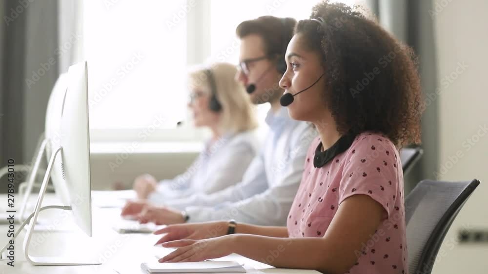African female call center agent using computer consulting customer African female call center agent using computer consulting customer