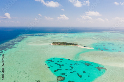 Onok Island Balabac, Philippines. The island of white sand on a large atoll, view from above. Tropical island with palm trees. Seascape with a paradise island.