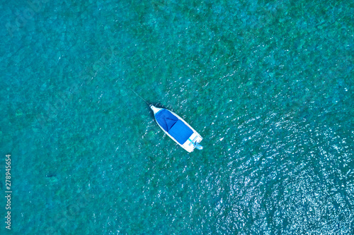 The yacht is white on turquoise water, parking on the water, a top view. Aerial photography with drone.  © Berg