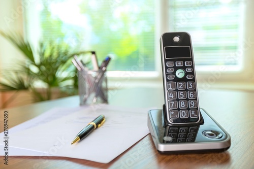 Billede på lærred Wireless Telephone on a Wooden Desk