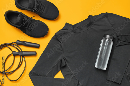 Close-up studio shot of a gym accessories on a yellow background. Top view, flat lay. © nazarovsergey