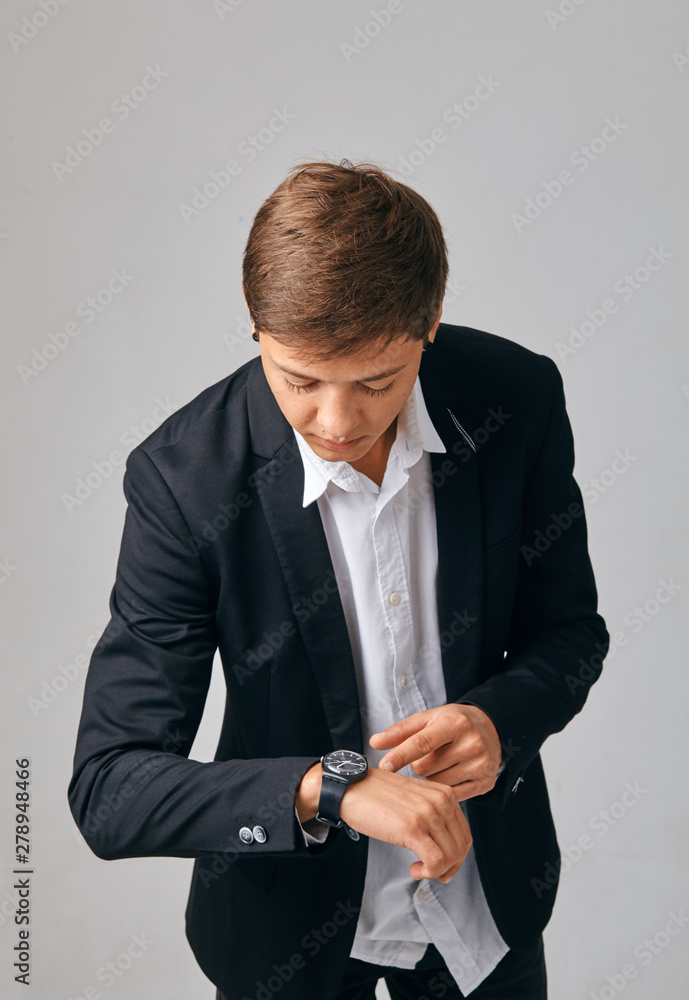 Young businesswoman looking at her watch in a stylish jacket Young businesswoman looking at her watch in a stylish jacket