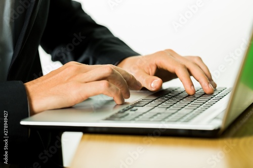 Fototapeta Naklejka Na Ścianę i Meble -  Closeup of a Businessman Using a Laptop