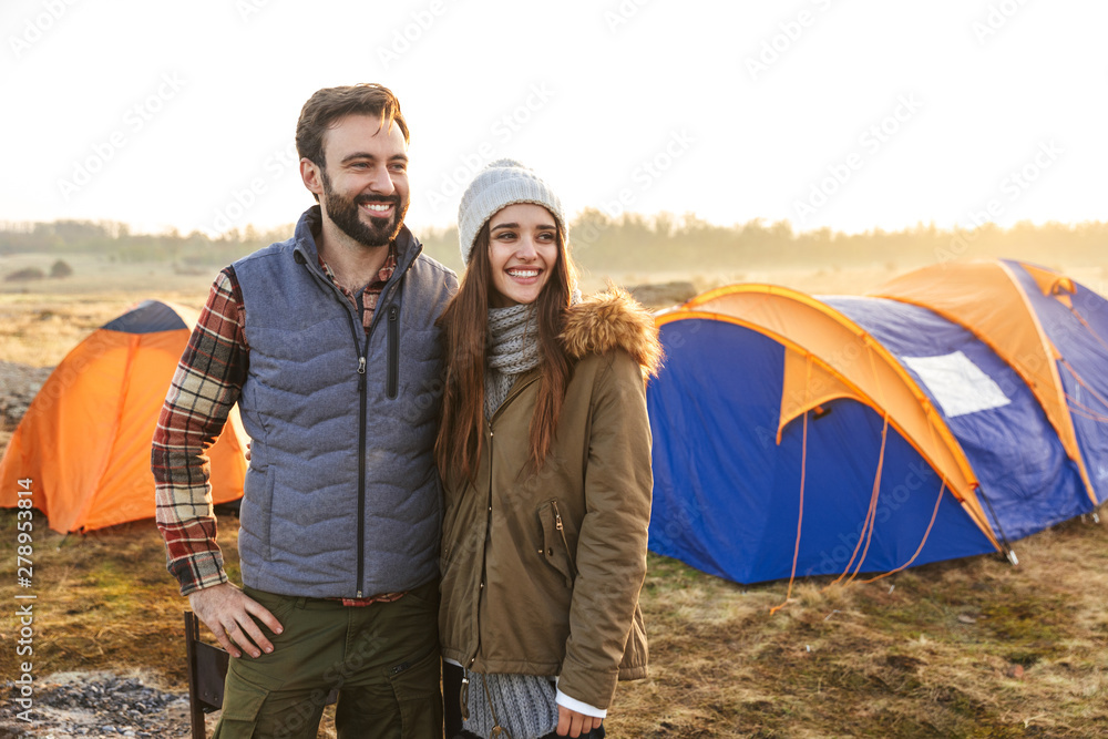 Happy young loving couple outside with tent in free alternative vacation camping over mountains. Happy young loving couple outside with tent in free alternative vacation camping over mountains.