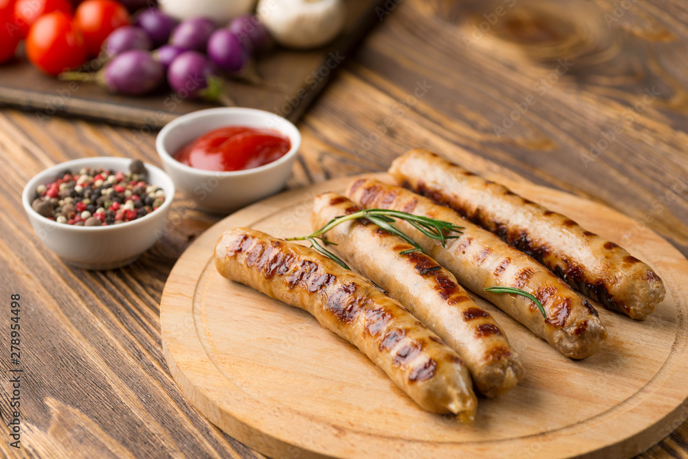 Grilled sausages with sauce ketchup on a wooden table Grilled sausages with sauce ketchup on a wooden table