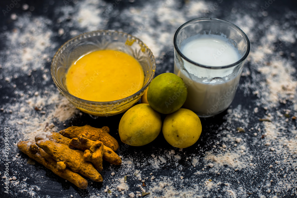 Lemon face mask on the wooden surface consisting lemon juice, gram flour or  chickpea flour, turmeric or Haldi and milk in a glass bowl.For the  treatment of tans. Stock Photo | Adobe