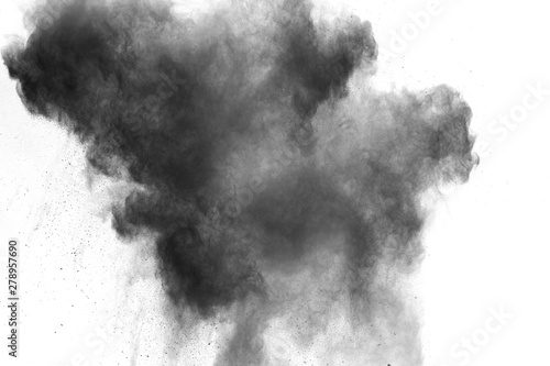 Black powder explosion on white background. Abstract black dust particles splash on white background.