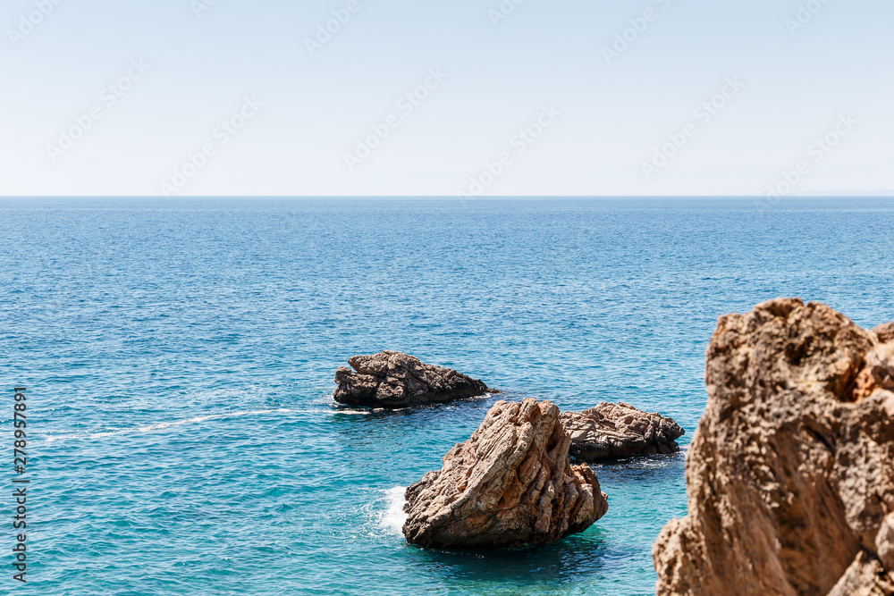 Beautiful seascape. Seascape on the background of the wild rocky coast. Wild beach, azure water and rocks. Luxury summer adventure, Mediterranean sea, Turkey. Postcard view