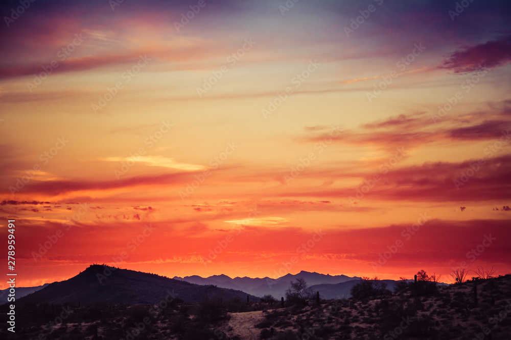 A sunset over a distant mountain in the Sonoran Desert of Arizona