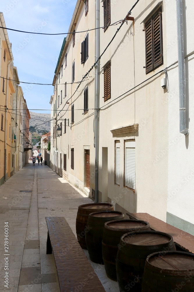 Traditional barrels set as tables on the narrow street of town Pag, island Pag, Croatia.
