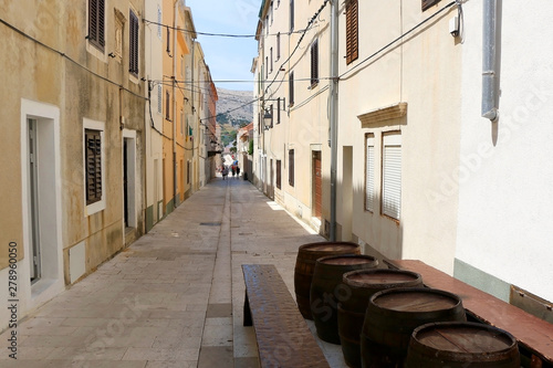 Traditional barrels set as tables on the narrow street of town Pag, island Pag, Croatia.