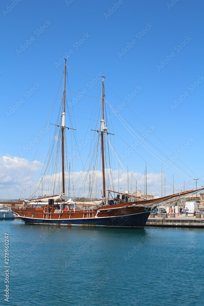 Old discharged sailing ship in Syracuse harbor (Italy)