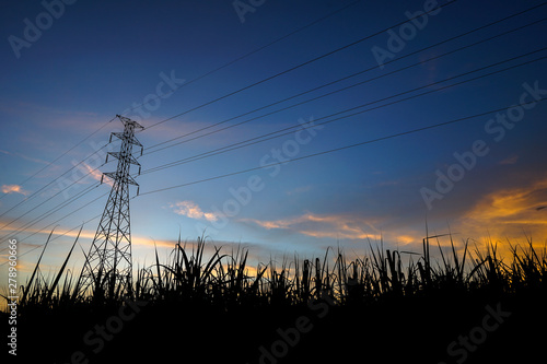 High voltage electrical pole and transfer cable line with dramatic orange lighting sky as the background, shadow and silhouette photo theme. Country infrastructure concept. photo