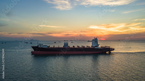 Container ship at sunset, Logistics and transportation of international container ship in the sea.