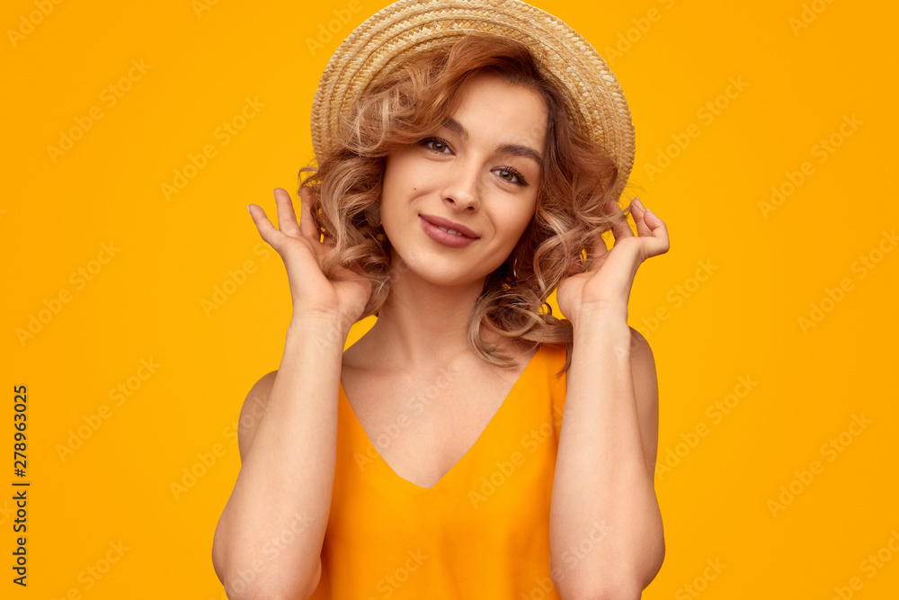 Stylish lady in summer hat looking at camera