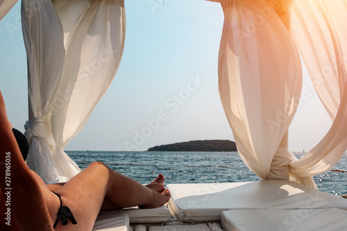 A woman relaxing in the sunshine and looking at beautiful beach and ocean and mountains © magdal3na