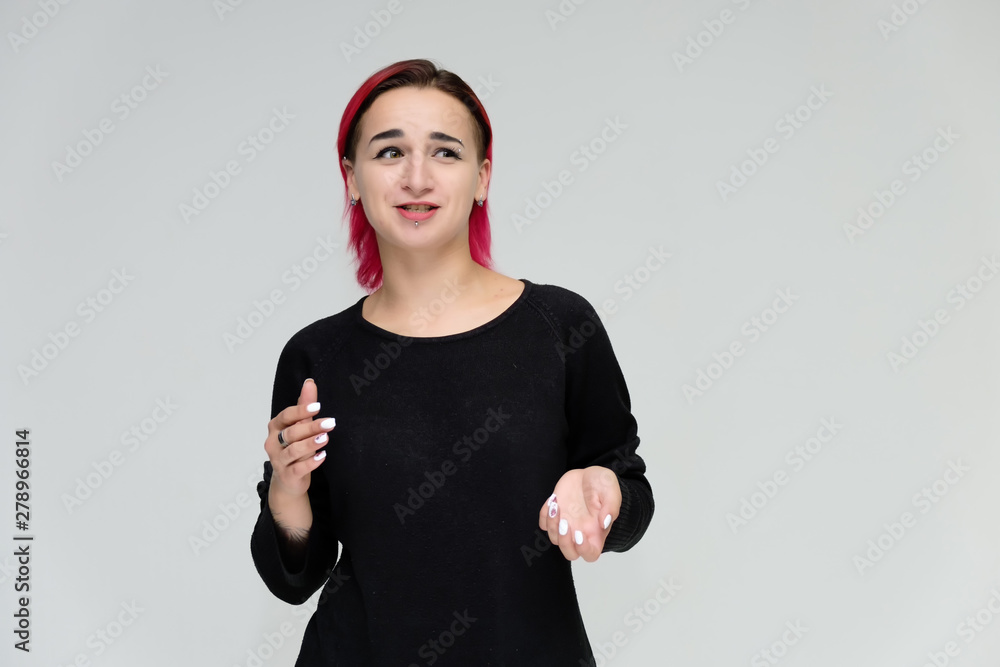 Portrait to the waist of a pretty girl with red hair on a white background in a black jacket. Standing right in front of the camera in a studio with emotions, talking, showing hands, smiling Portrait to the waist of a pretty girl with red hair on a white background in a black jacket. Standing right in front of the camera in a studio with emotions, talking, showing hands, smiling