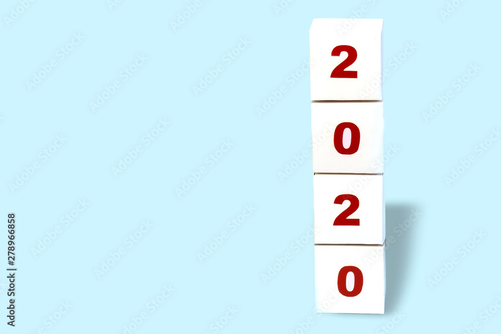 Happy new year 2020 on a cubic white paper block on a bright blue background, happy new year 2020 greeting card, banner. Copy space Happy new year 2020 on a cubic white paper block on a bright blue background, happy new year 2020 greeting card, banner. Copy space