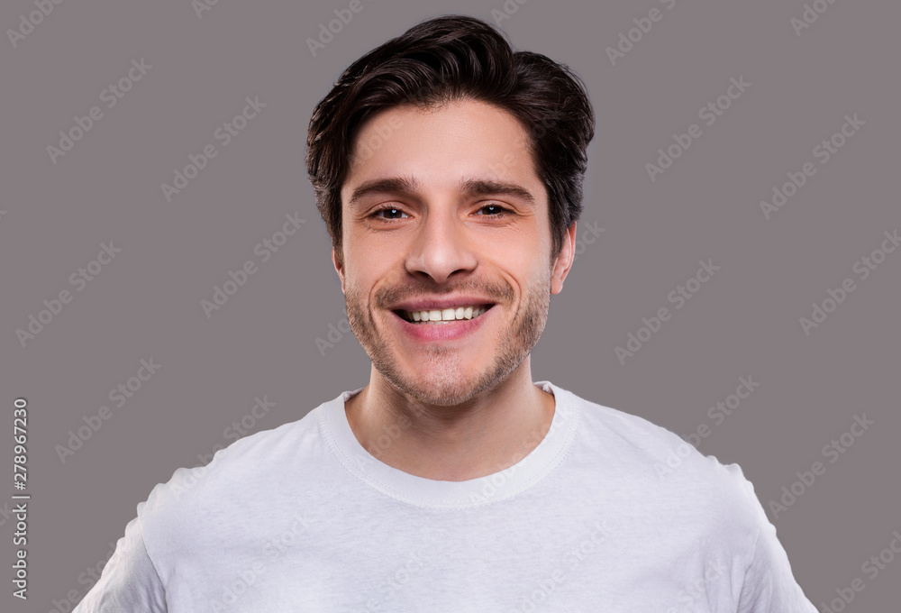 Handsome young caucasian man smiling at camera Handsome young caucasian man smiling at camera