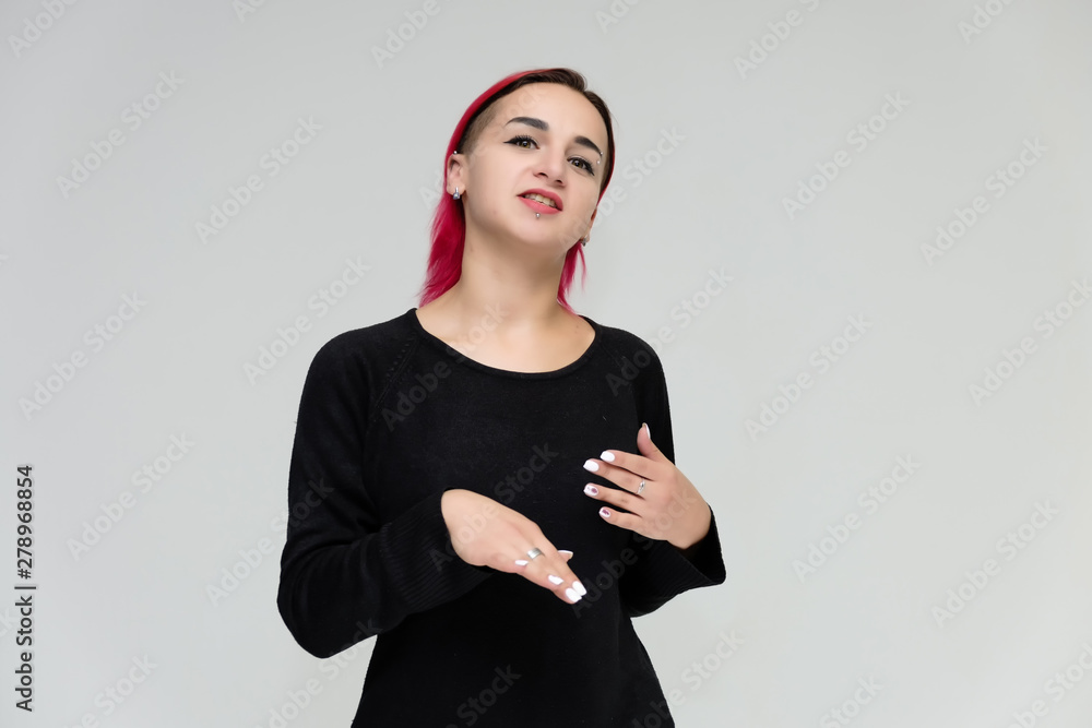 Portrait to the waist of a pretty girl with red hair on a white background in a black jacket. Standing right in front of the camera in a studio with emotions, talking, showing hands, smiling Portrait to the waist of a pretty girl with red hair on a white background in a black jacket. Standing right in front of the camera in a studio with emotions, talking, showing hands, smiling