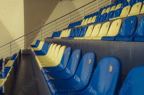 Stadium Seats. Sport arena blue and yellow plastic seats. Indoor.