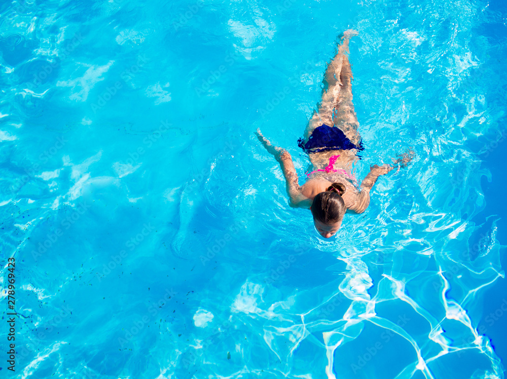 Aerial top view of woman in swimming pool water from above, tropical vacation holaday concept