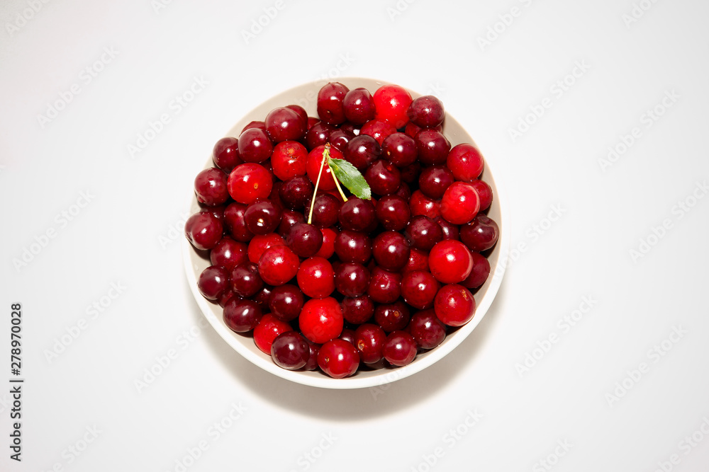 white plate with red cherry on white background white plate with red cherry on white background