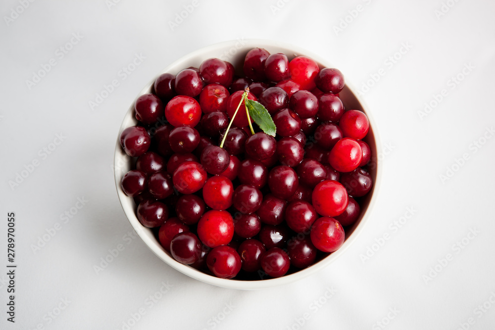 white plate with red cherry on white background white plate with red cherry on white background