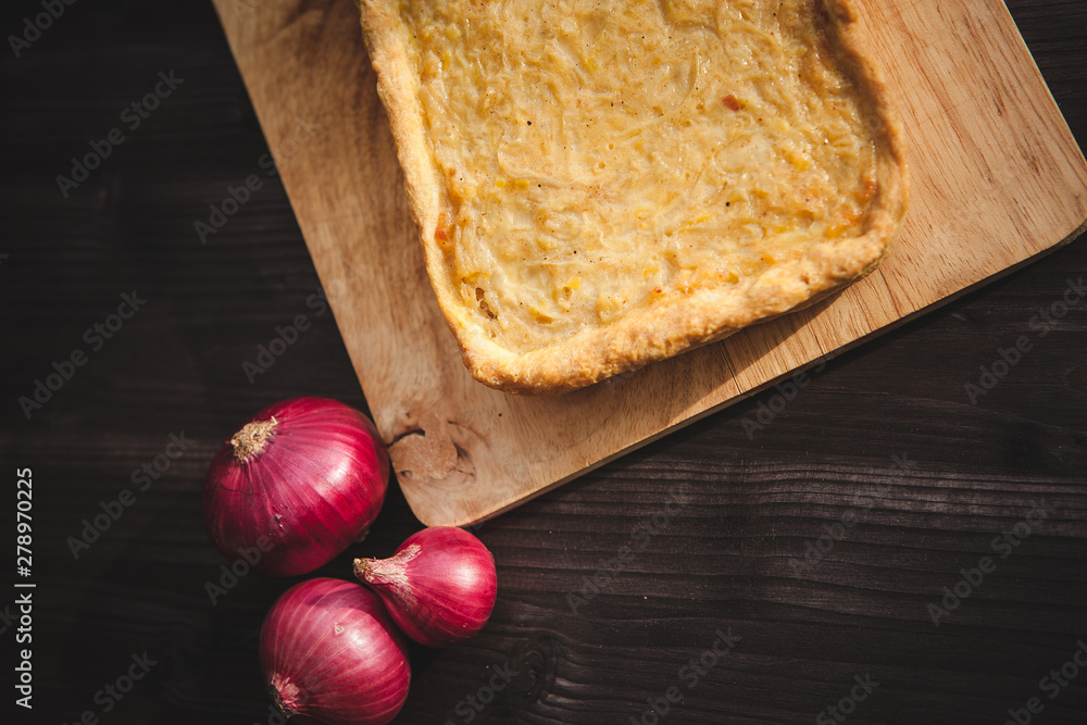  french onion cake on dark wooden background with red onions