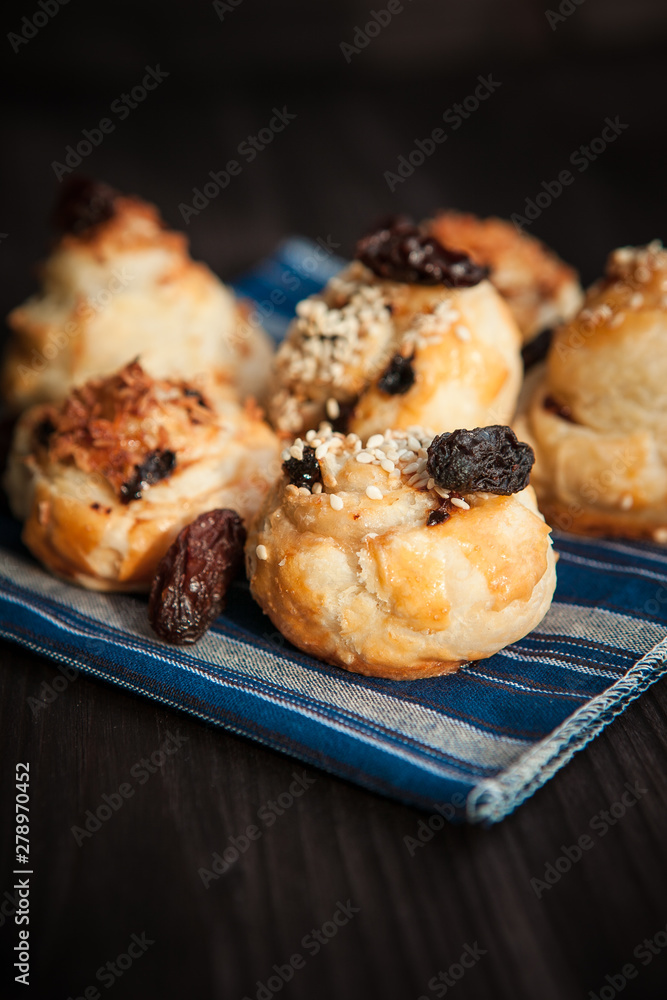  puff buns with raisins on a blue background