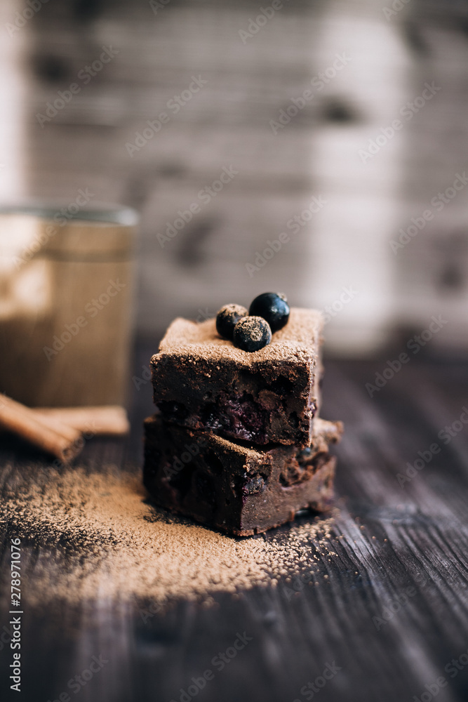 brownie cake on a dark background decorated with fresh berries and cocoa brownie cake on a dark background decorated with fresh berries and cocoa