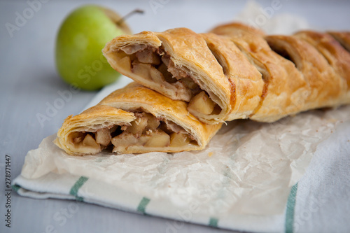 strudel with apple and cinnamon on a light towel, light background