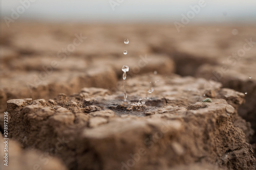 Water drop to dry cracked land metaphor lack of rain, water crisis, Climate change and Environmental disaster photo