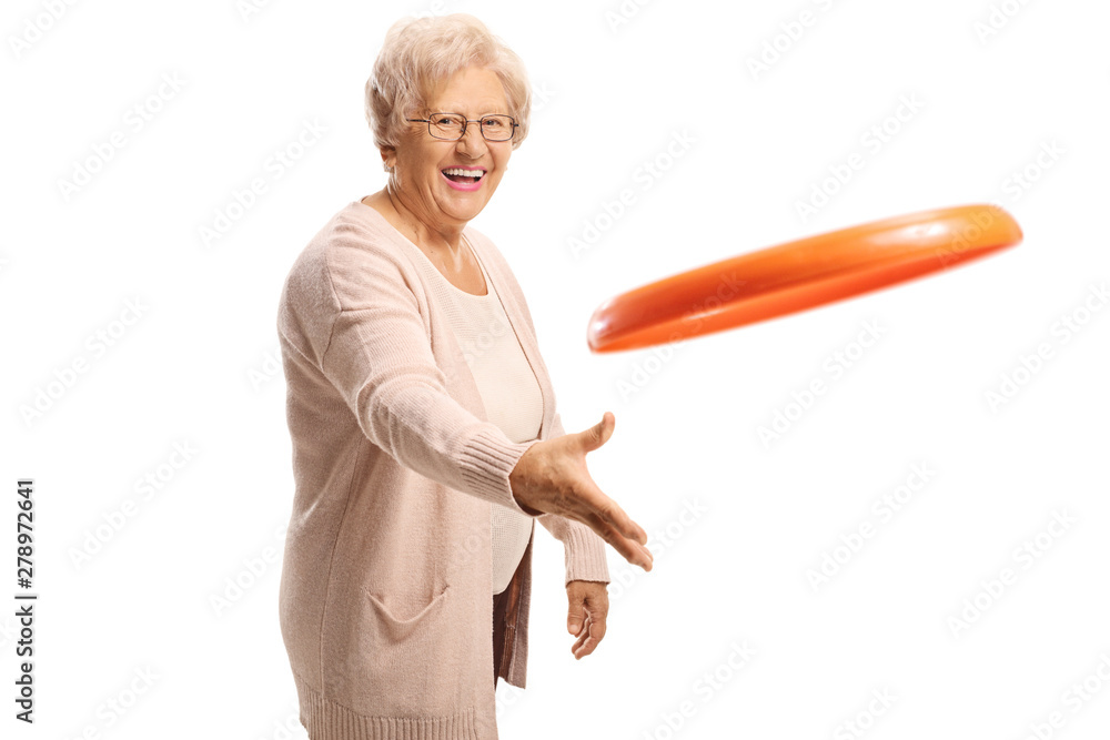 Cheerful elderly woman throwing a plastic disc Cheerful elderly woman throwing a plastic disc